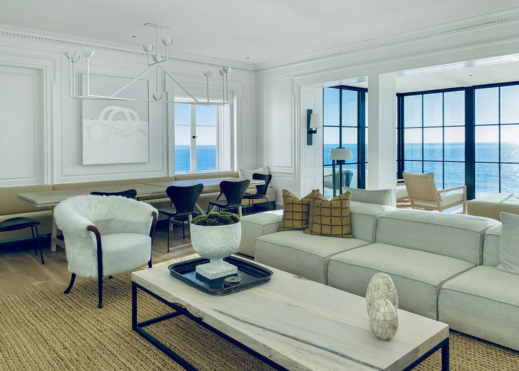 A light-filled coastal living room with ocean views and curated artwork — a Susan Street Fine Art residential consulting project.