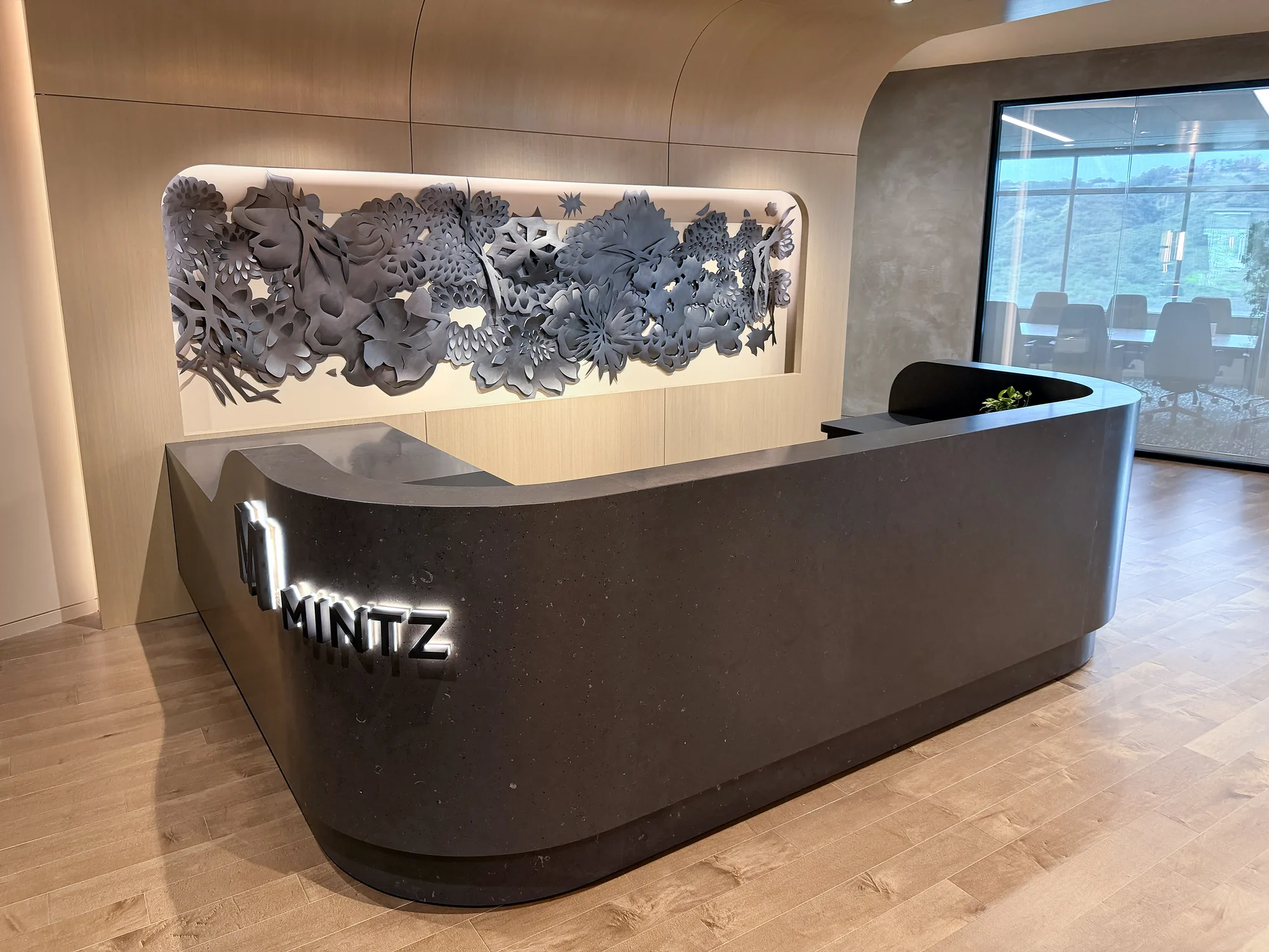 The Mintz law office reception desk beneath a carved-paper relief by Andreas Kocks — a Susan Street Fine Art corporate project.