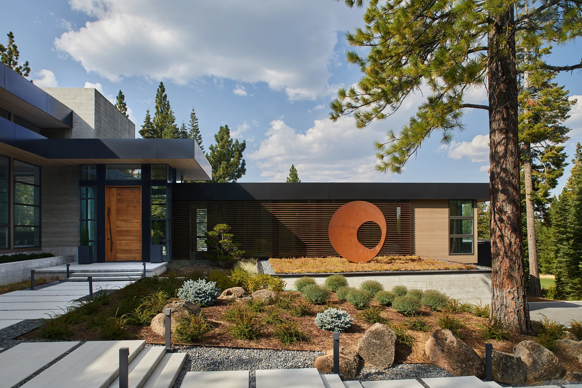 A modern Lake Tahoe residence with a Corten steel ring sculpture in the entry garden — a Susan Street Fine Art residential project.